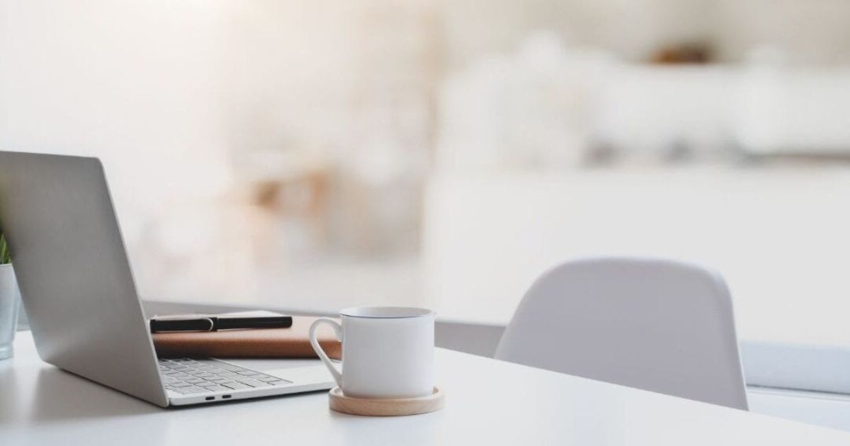 coffee cup and laptop on a desk