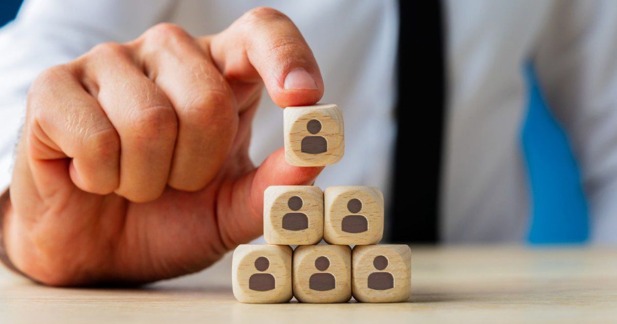man stacking dice with person figures